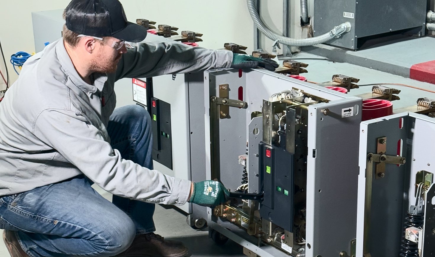 Technician racking a low-voltage breaker during acceptance testing